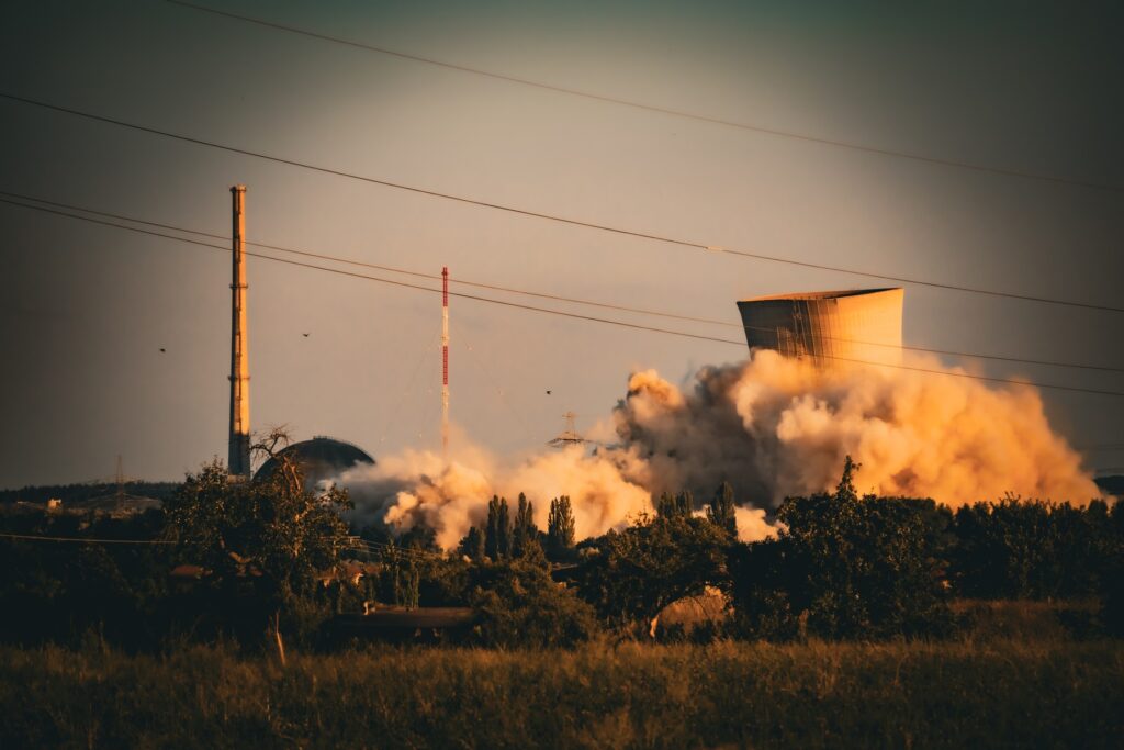 A cooling tower collapsing in a cloud of dust during the controlled demolition of a nuclear power plant.
