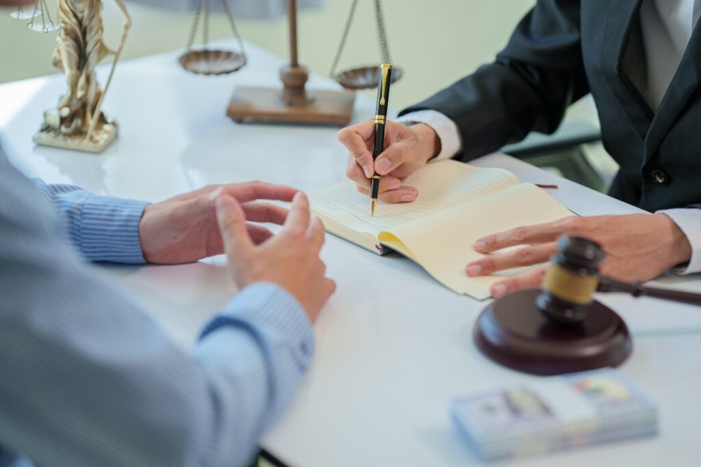 Two professionals reviewing and signing a contract document together in an office setting.