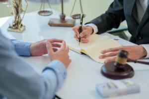 Two professionals reviewing and signing a contract document together in an office setting.