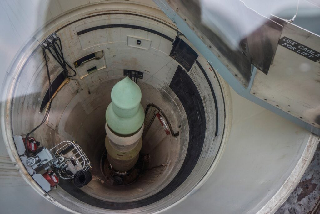 A ballistic missile warhead stored upright inside an underground launch silo, viewed from above.